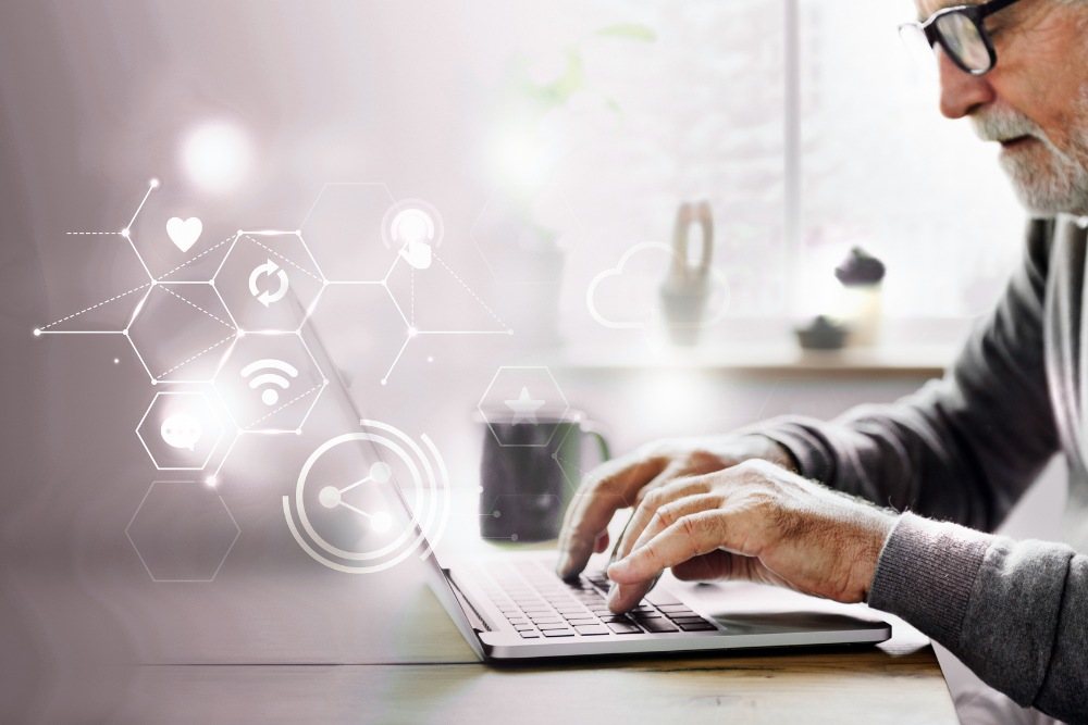 Profissional utilizando notebook em ambiente de trabalho, com ícones digitais de conectividade e rede sobrepostos à imagem, representando conexão móvel e integração de dispositivos IoT.